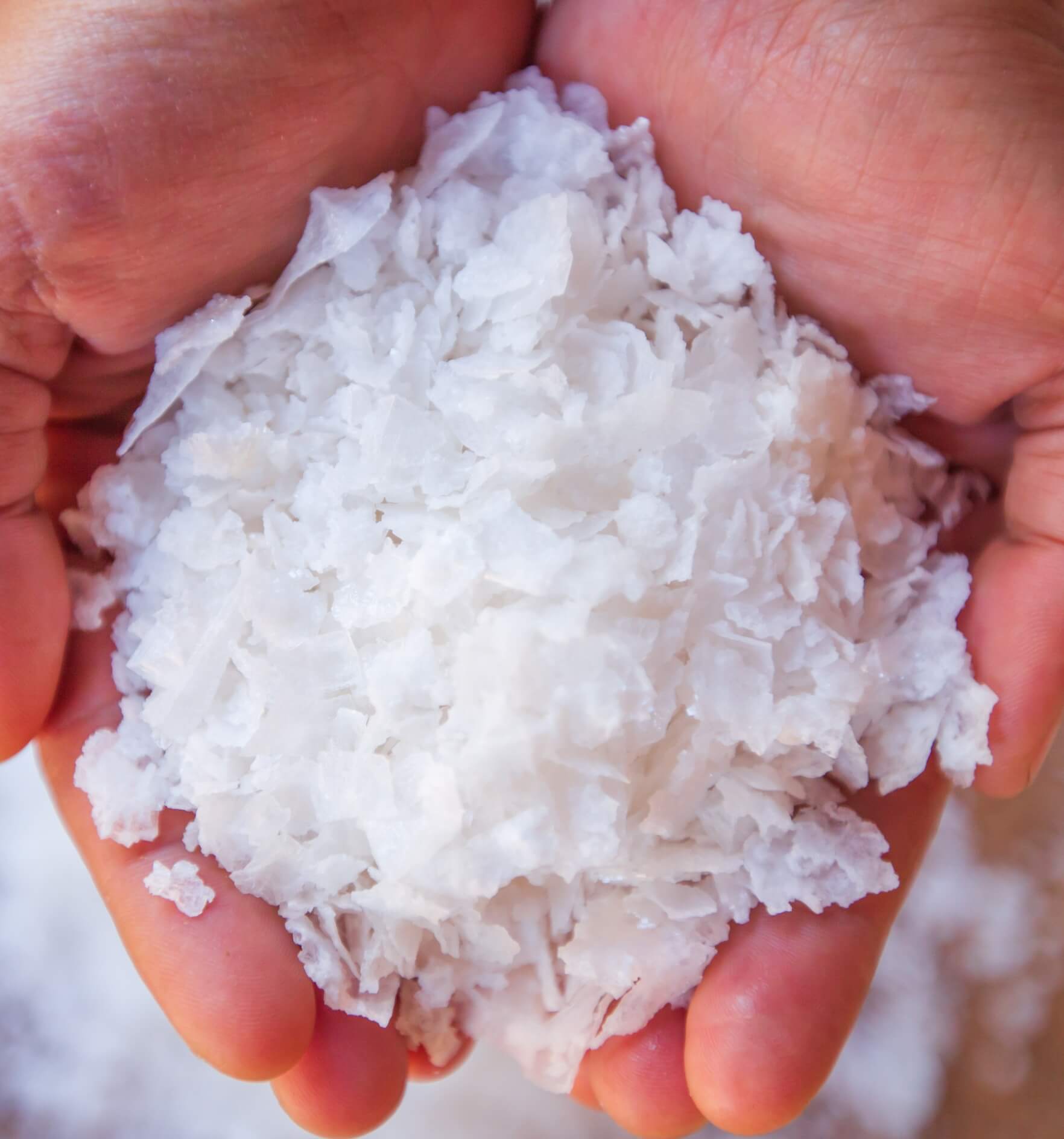 Image showing pure white crystals salt, rock salt in woman hands on crystals backgrounds