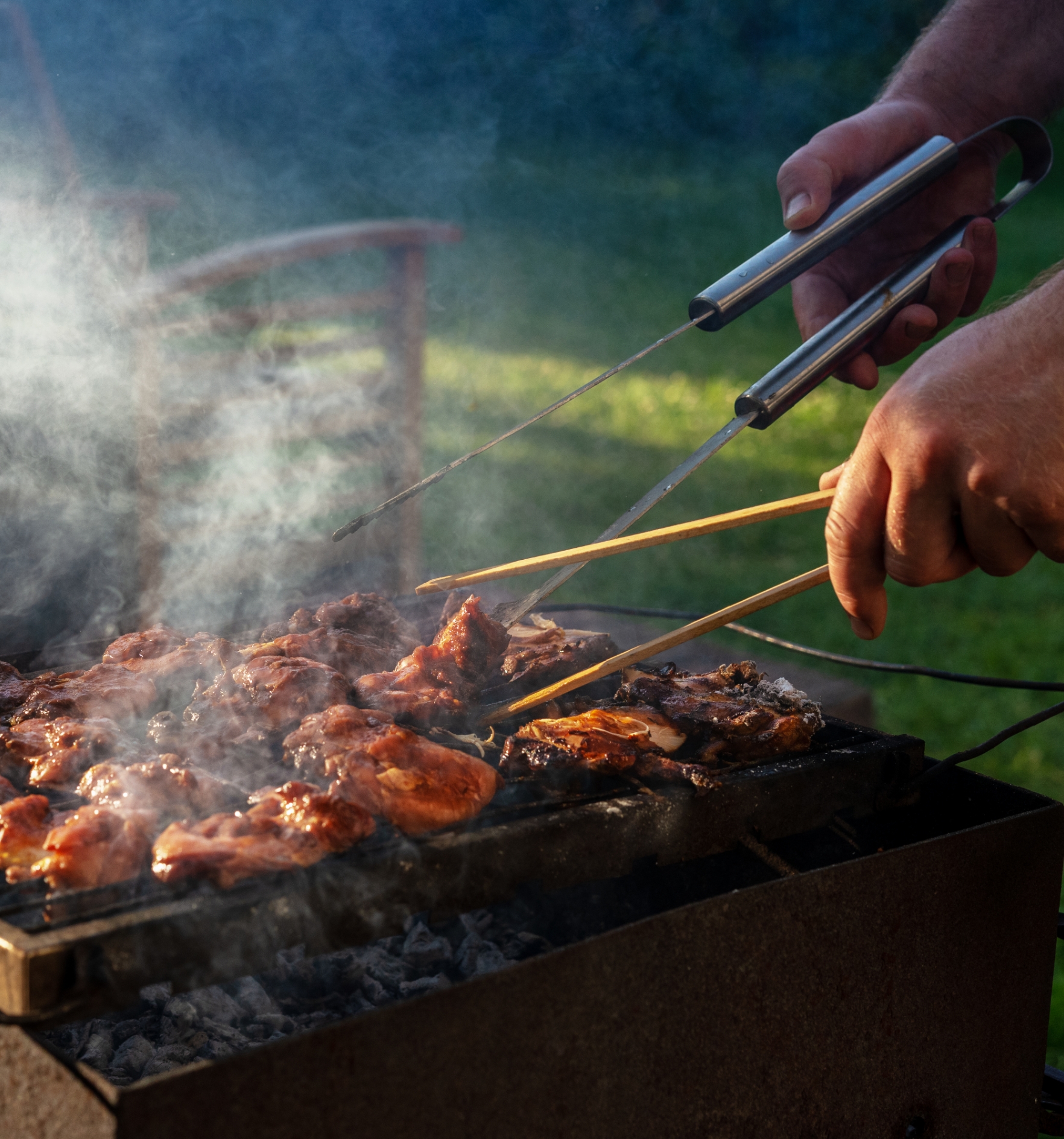 Image showing a man handling meat on a barbecue