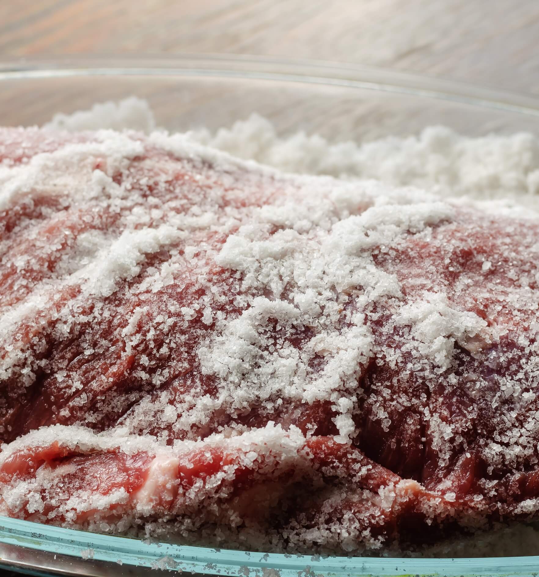 Image showing raw pork meat covered with salt in glass bowl