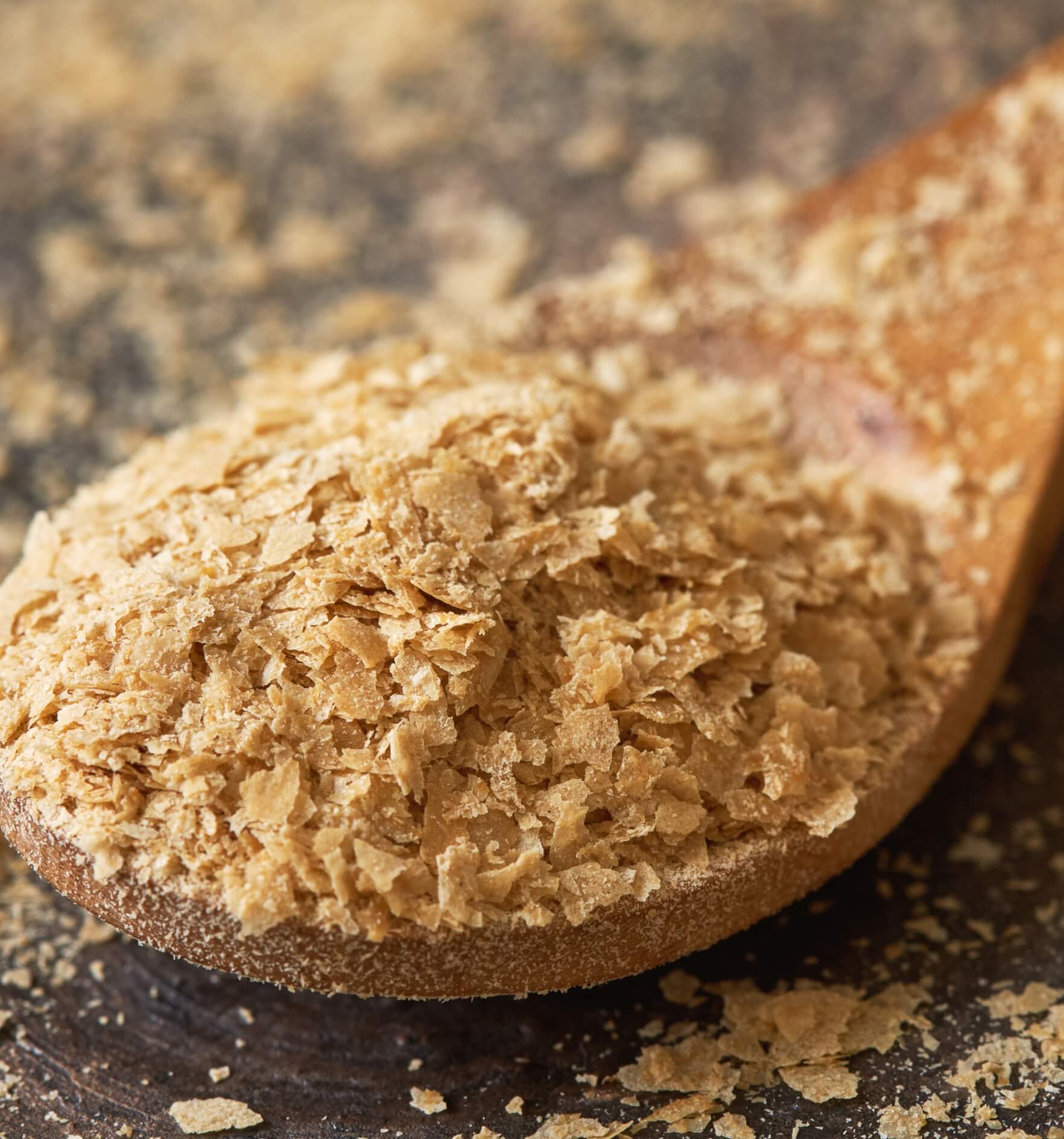 image showing a closeup of nutritional brewers yeast flakes in wooden spoon